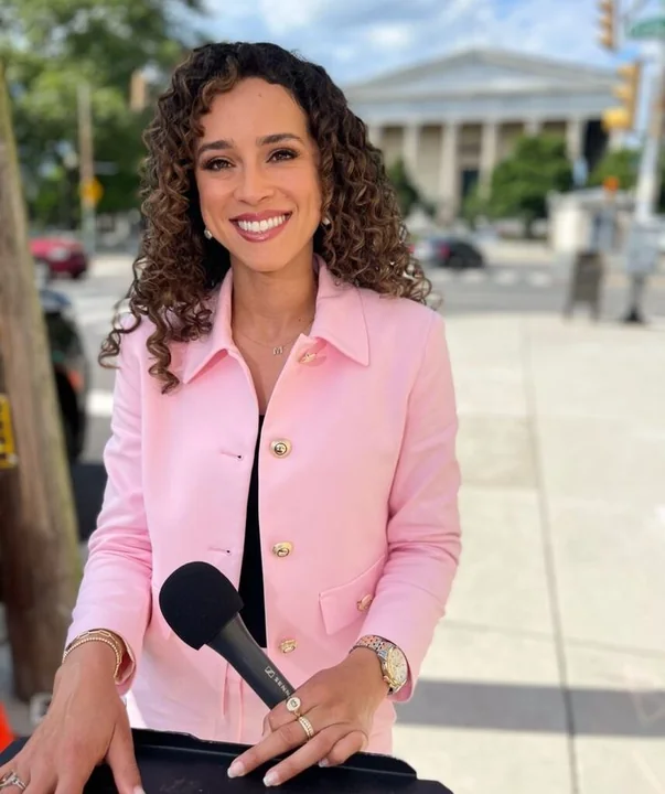 Madison Alworth reporting on location in a pink blazer, holding a microphone