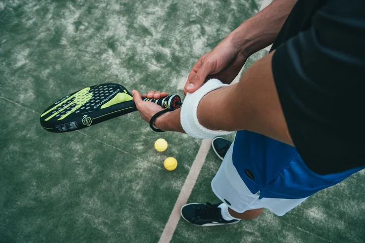 A player bending to pick up a ball on court