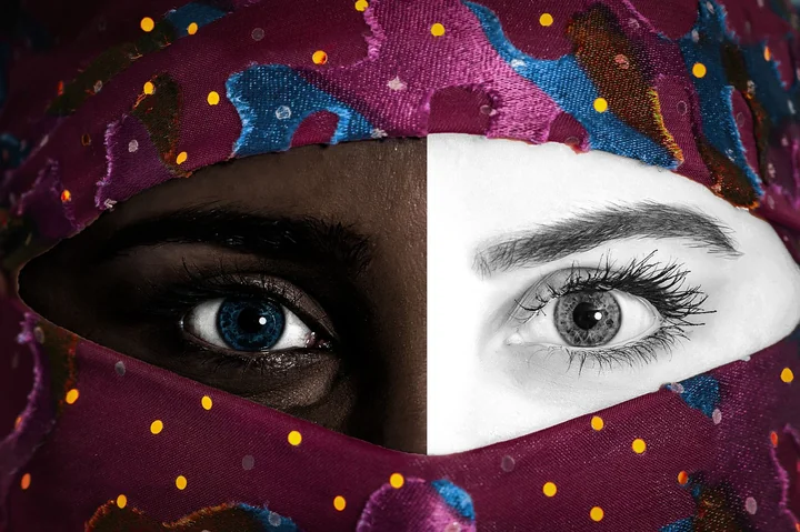 A close-up of eyes above patterned fabric