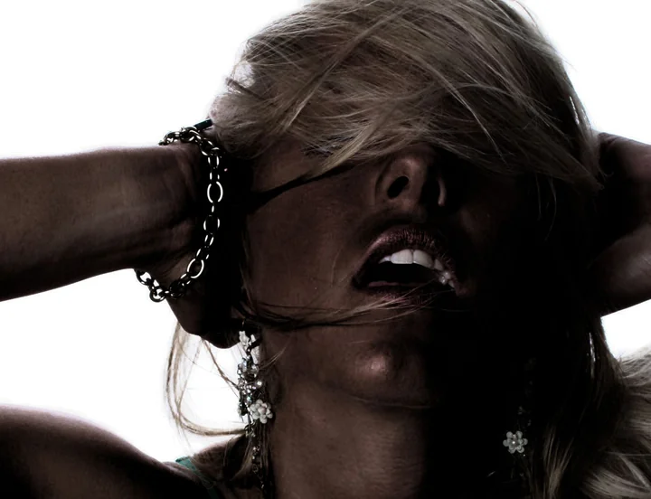 A portrait of a woman with her hair falling across her face