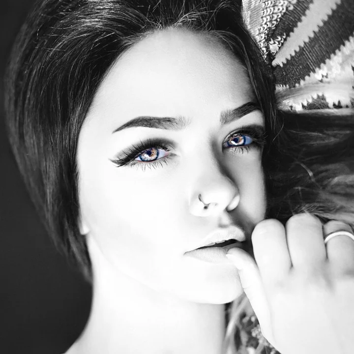 A black and white portrait of a woman resting her chin on her hand