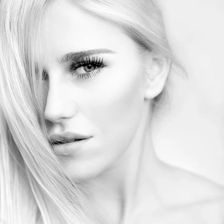 A black and white portrait of a woman looking to camera