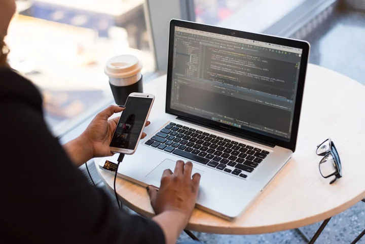 A person working at a laptop with a coffee