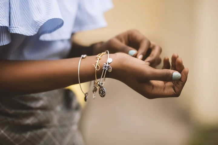 Hands wearing delicate bracelets and rings