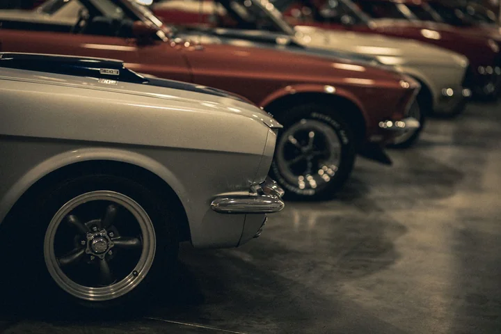 A line of vintage cars parked in a museum hall