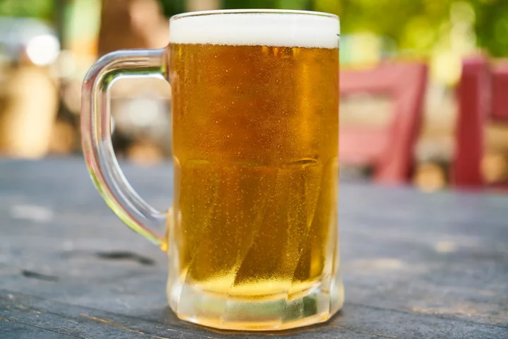 A glass tankard of beer on a wooden table