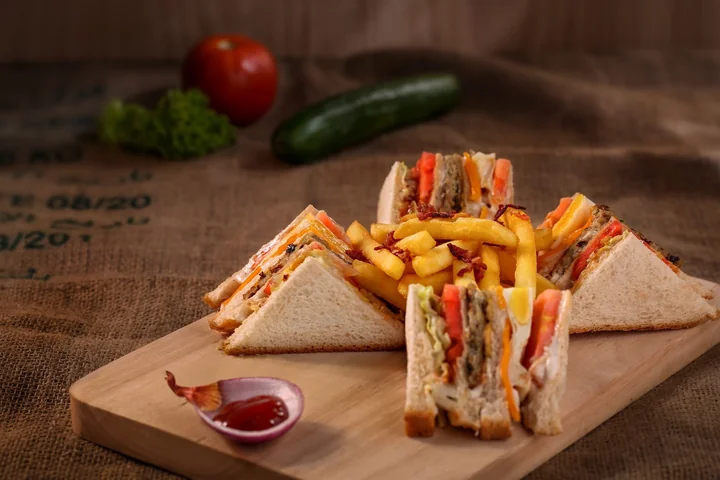 A club sandwich served with fries and ketchup