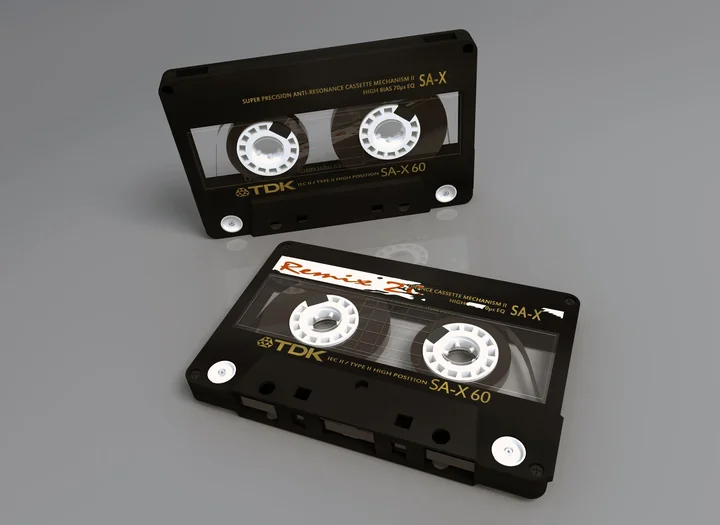 Two cassette tapes on a plain grey surface
