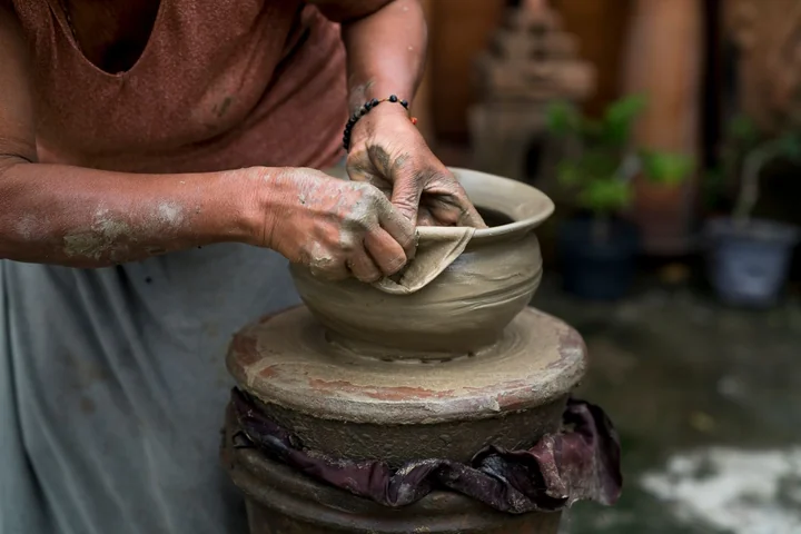 A potter working clay on a wheel