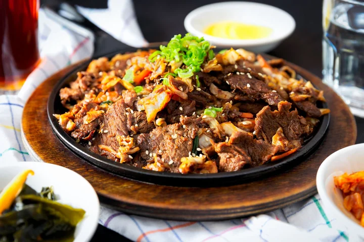 A meat dish served in a pan with side bowls