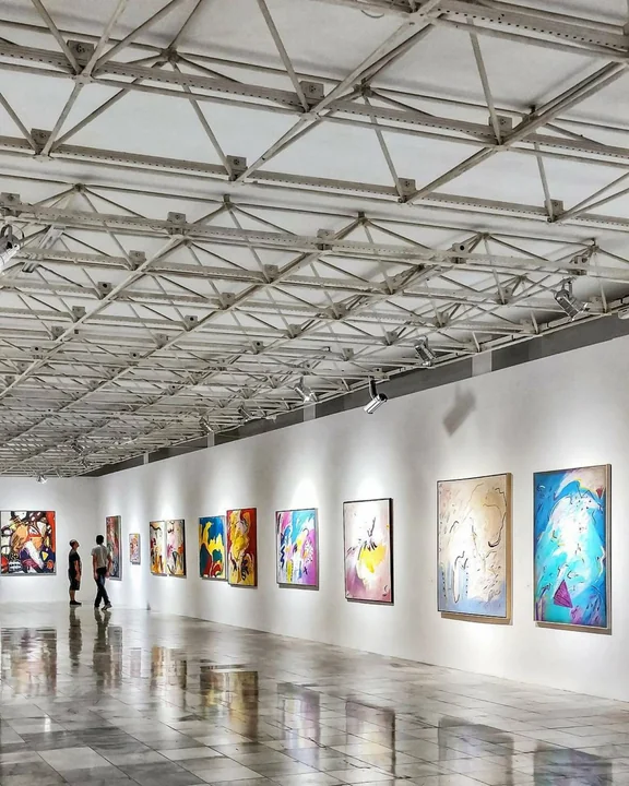 A gallery corridor hung with framed pictures