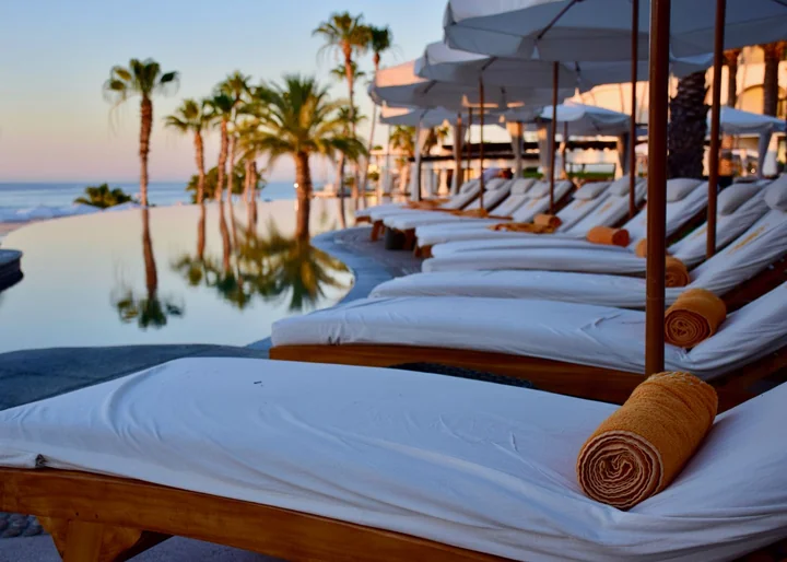 Sun loungers and palm trees at dusk