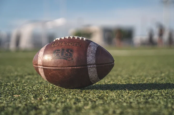 An American football resting on grass