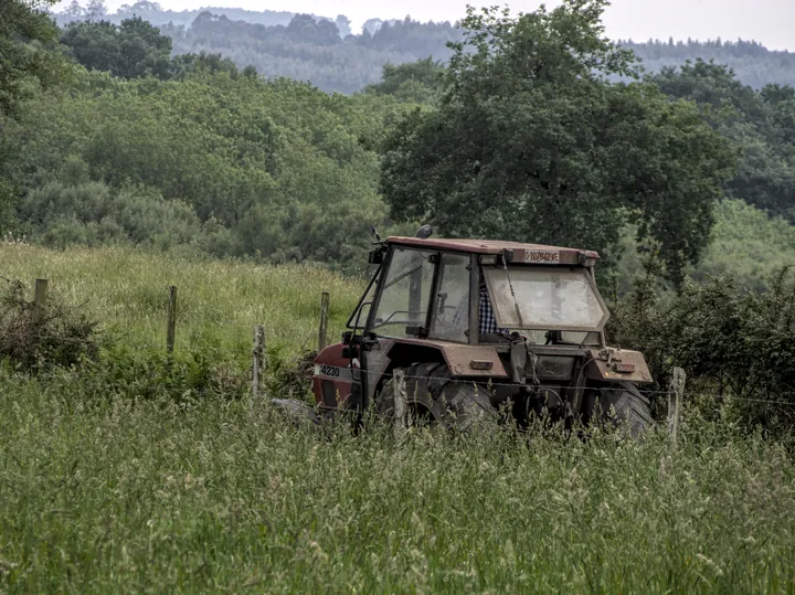 An old tractor standing in a rough field