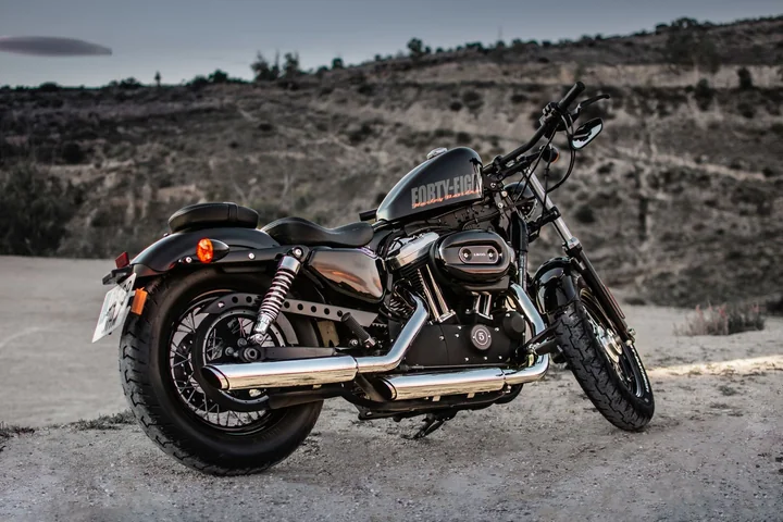 A motorcycle parked on a road across open hillside