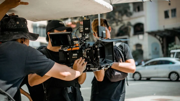 A film crew working with a camera outdoors