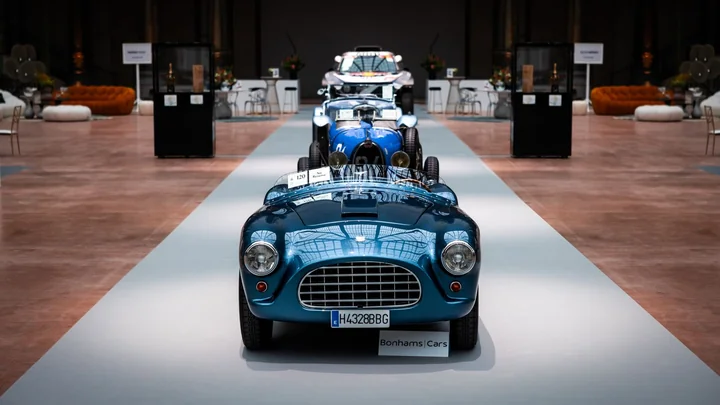 A blue classic racing car on display in a showroom