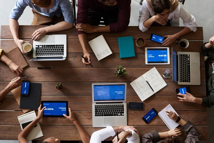 A meeting table seen from above with laptops and tablets