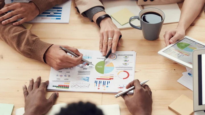 Hands working over printed charts and reports
