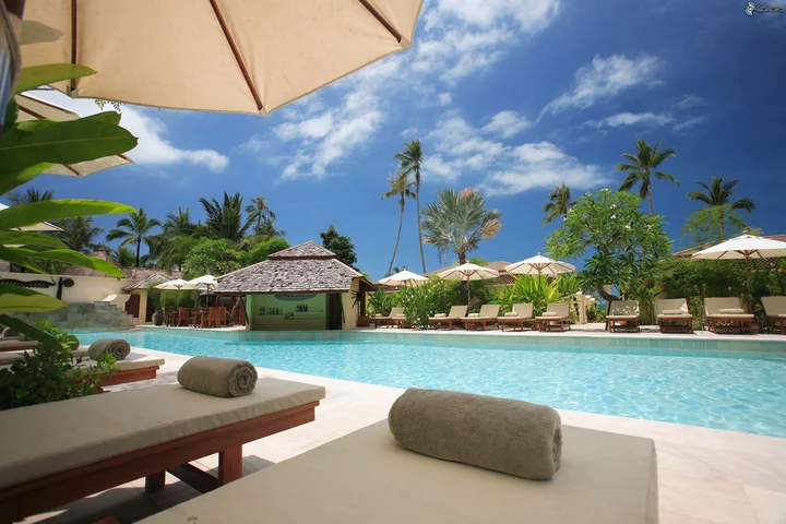 Sun loungers and parasols beside a resort pool