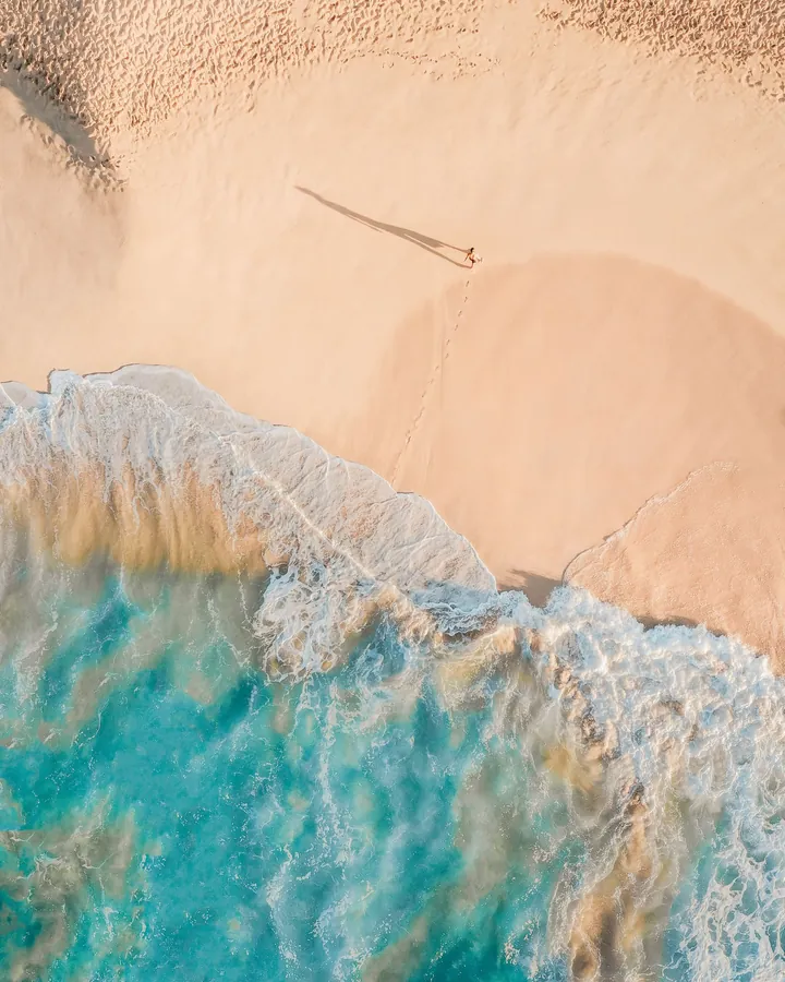 An aerial view of a beach and shallow sea