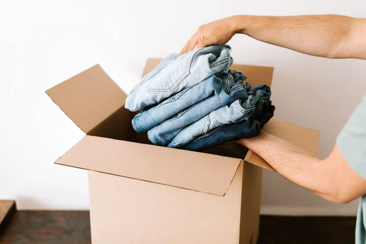 Folded clothes being packed into a cardboard box