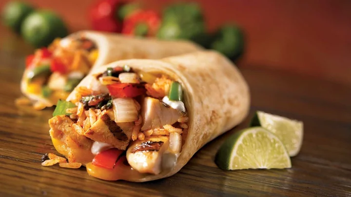 A filled wrap served with salad and lime