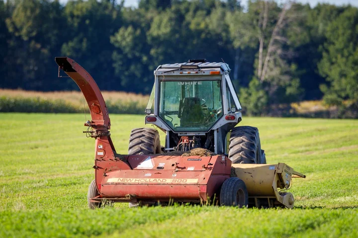 A tractor pulling a mower across a grass field