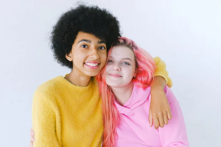 Two friends sitting together and smiling