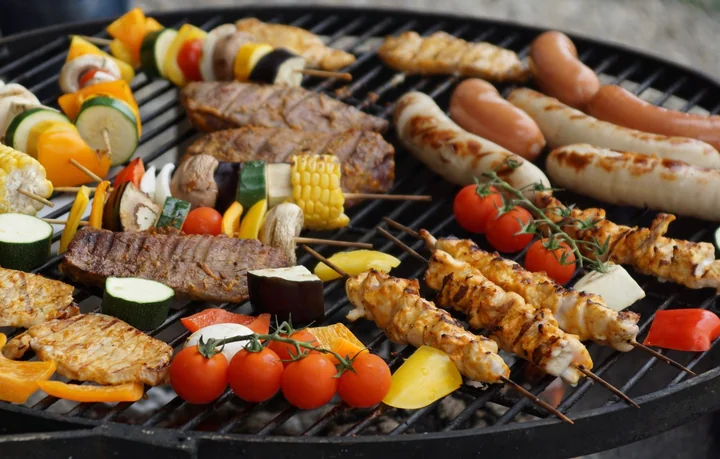 Skewers and vegetables cooking on a barbecue