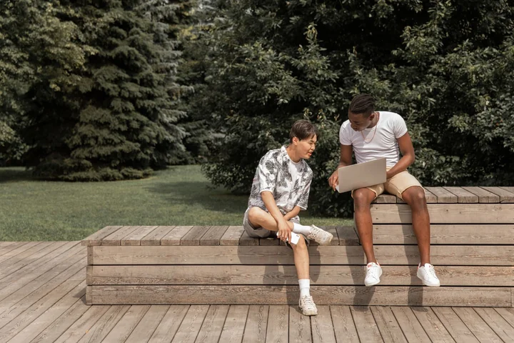 Two people talking on a bench in a park