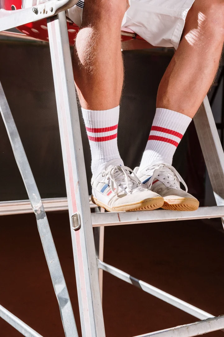Legs and trainers resting on a white chair