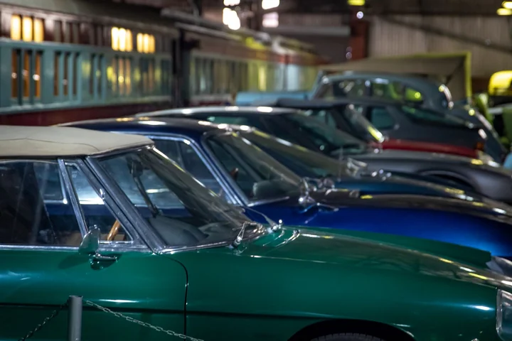 A row of classic cars lined up in a showroom