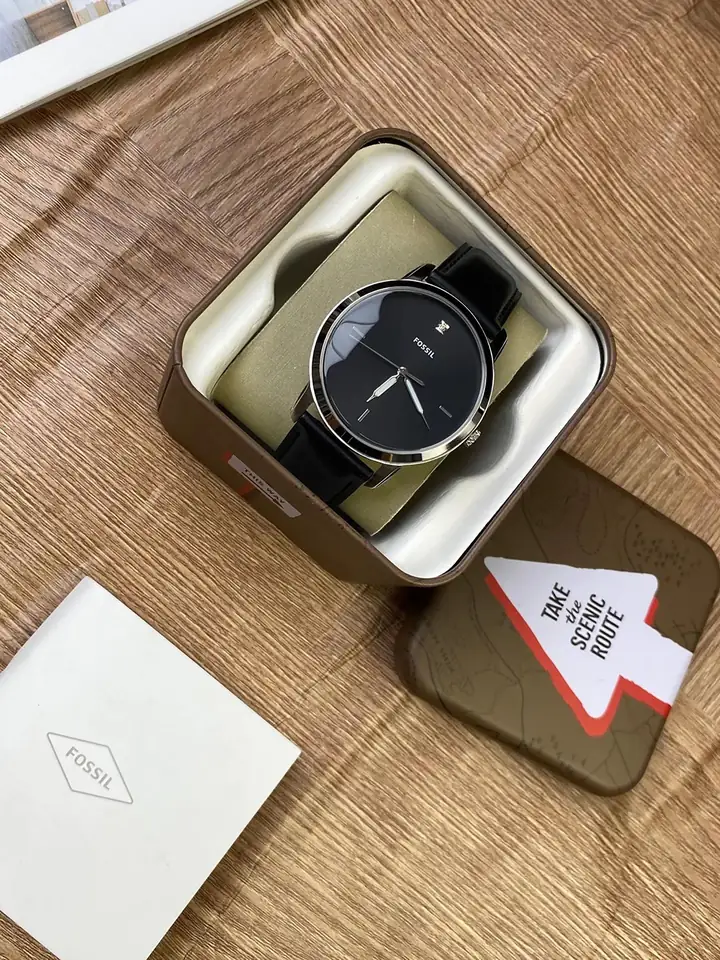 A wristwatch in a presentation box on a wooden table
