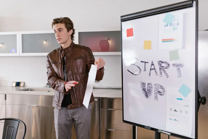 A man presenting at a whiteboard headed start up