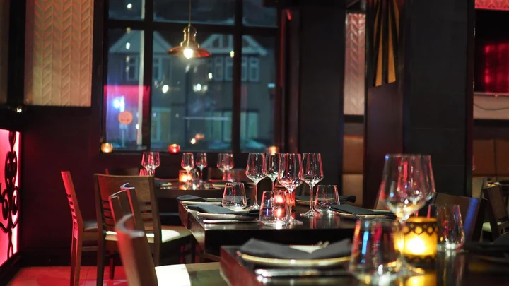 A restaurant dining room with tables and wine glasses