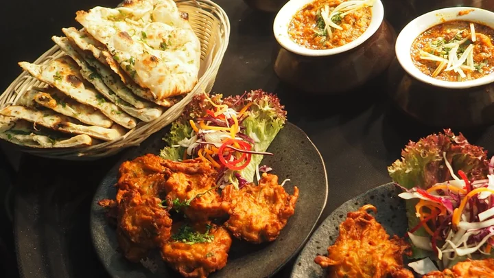 A shared table of curries, fritters and flatbreads